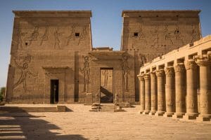The grand entrance of Luxor Temple at sunset, featuring the ancient pylon, towering columns, and an obelisk in the heart of Luxor, Egypt.