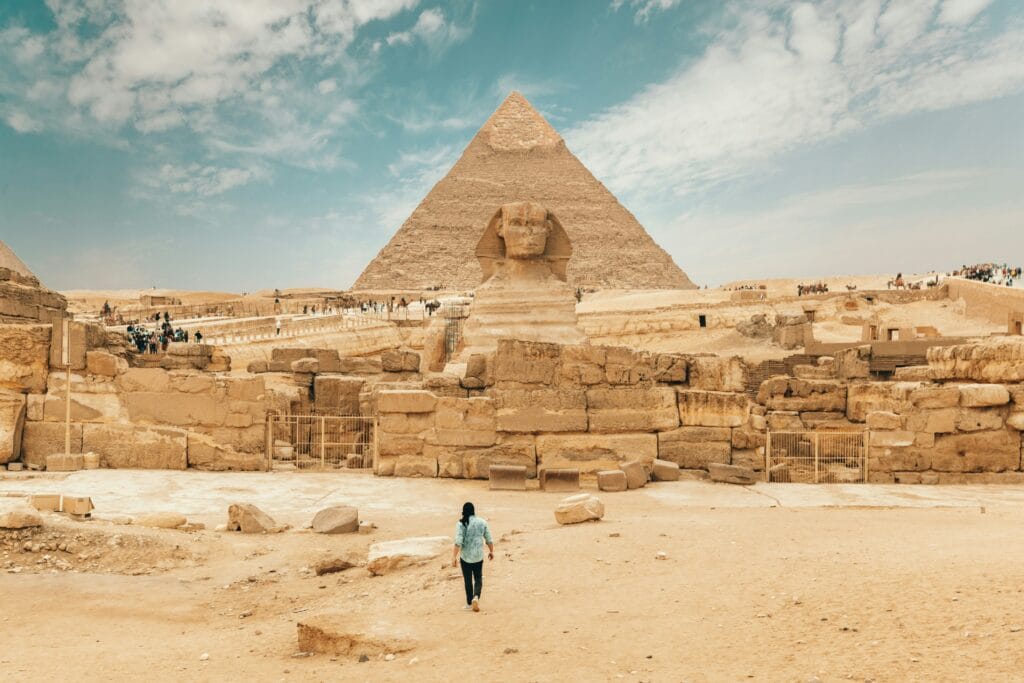 A traveler walking toward the Great Sphinx and the Pyramid of Khafre during a private, expert-led day trip from Hurghada with Top Class Egypt Travel.