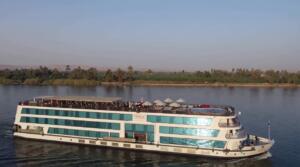 Aerial view of MS Amwaj luxury Nile cruise ship sailing on the Nile River surrounded by lush palm trees in Egypt