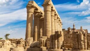 A row of towering ancient Egyptian stone columns with papyrus-style capitals at Luxor Temple.
