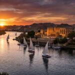 A panoramic, high-resolution view of the Nile River in Aswan with traditional white-sailed feluccas gliding past the illuminated Philae Temple during a vibrant sunset.