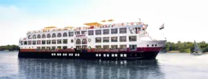 Profile view of Mövenpick MS Sun Ray luxury cruise vessel sailing past green palm trees on the Nile River