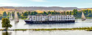 Mövenpick MS Sun Ray cruise ship navigating the Nile with desert hills and palm trees in the background