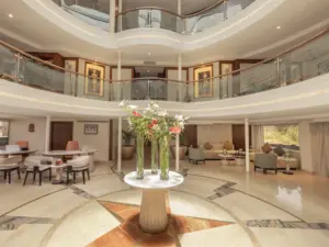 Grand multi-level cruise atrium lobby with marble compass floor, glass balustrades, and fresh flower centerpiece