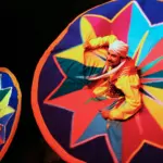 Close-up view of a smiling performer during a vibrant Whirling Tanoura Egypt cultural show, highlighting traditional Sufi Whirling Dervish wear.