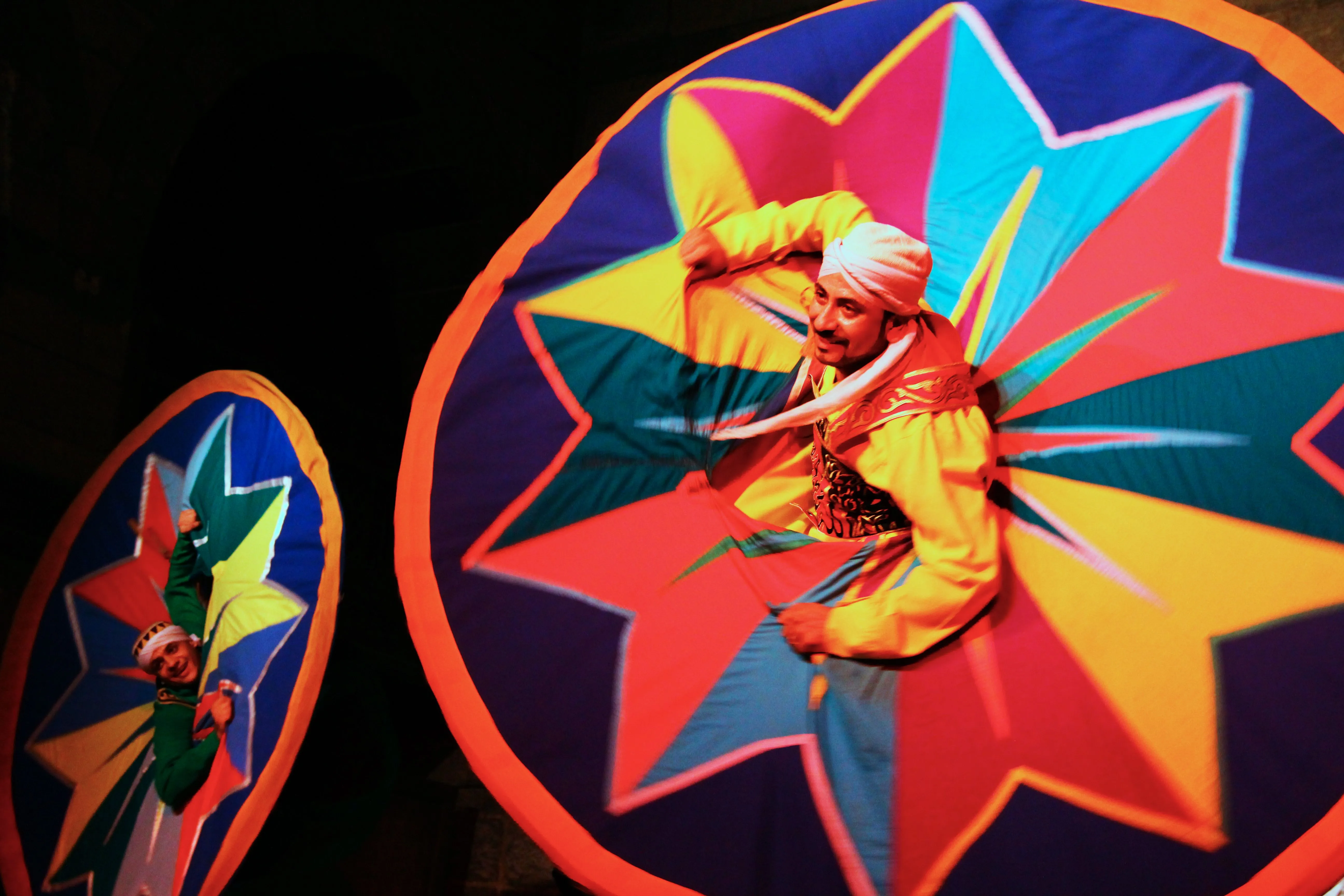 Close-up view of a smiling performer during a vibrant Whirling Tanoura Egypt cultural show, highlighting traditional Sufi Whirling Dervish wear.
