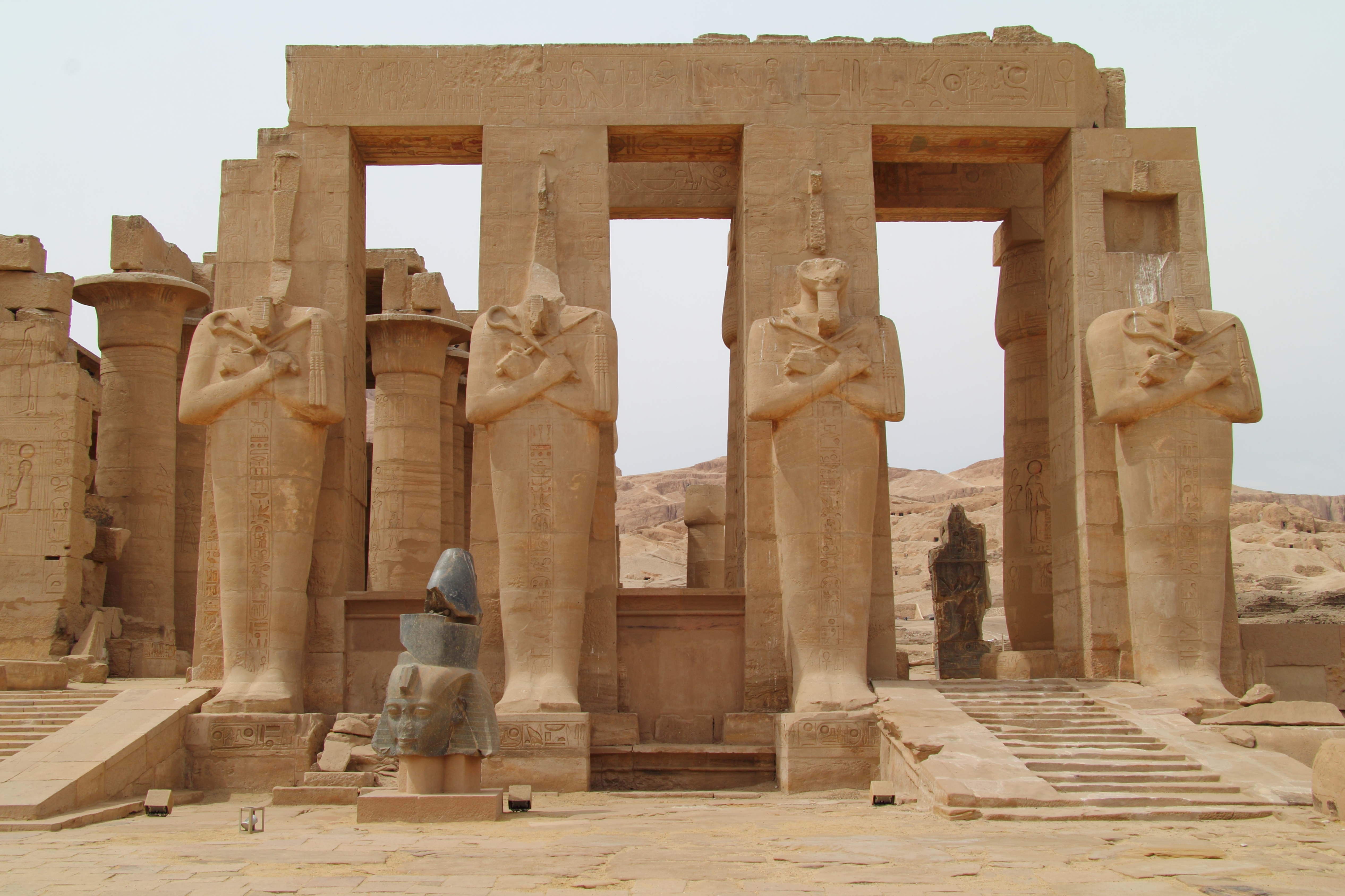The majestic Osiride columns and colossal fallen statues at the Ramesseum, a highlight of the private West Bank archaeological tours by Top Class Egypt Travel.