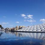 The modern exterior of the Bibliotheca Alexandrina reflecting in water, one of the top things to do in Alexandria, Egypt